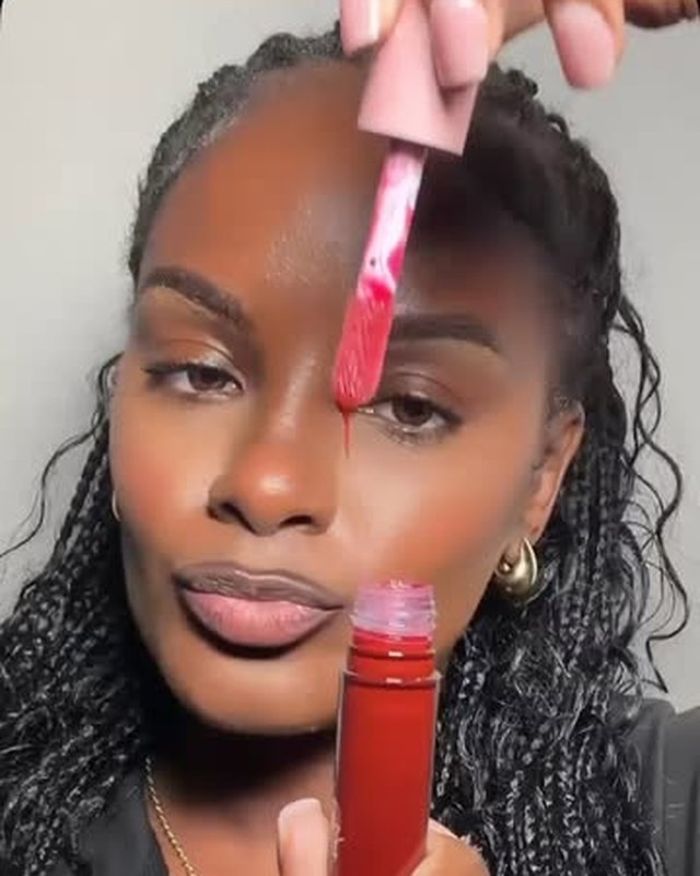 Model applying Thee Rich Girls red lip gloss