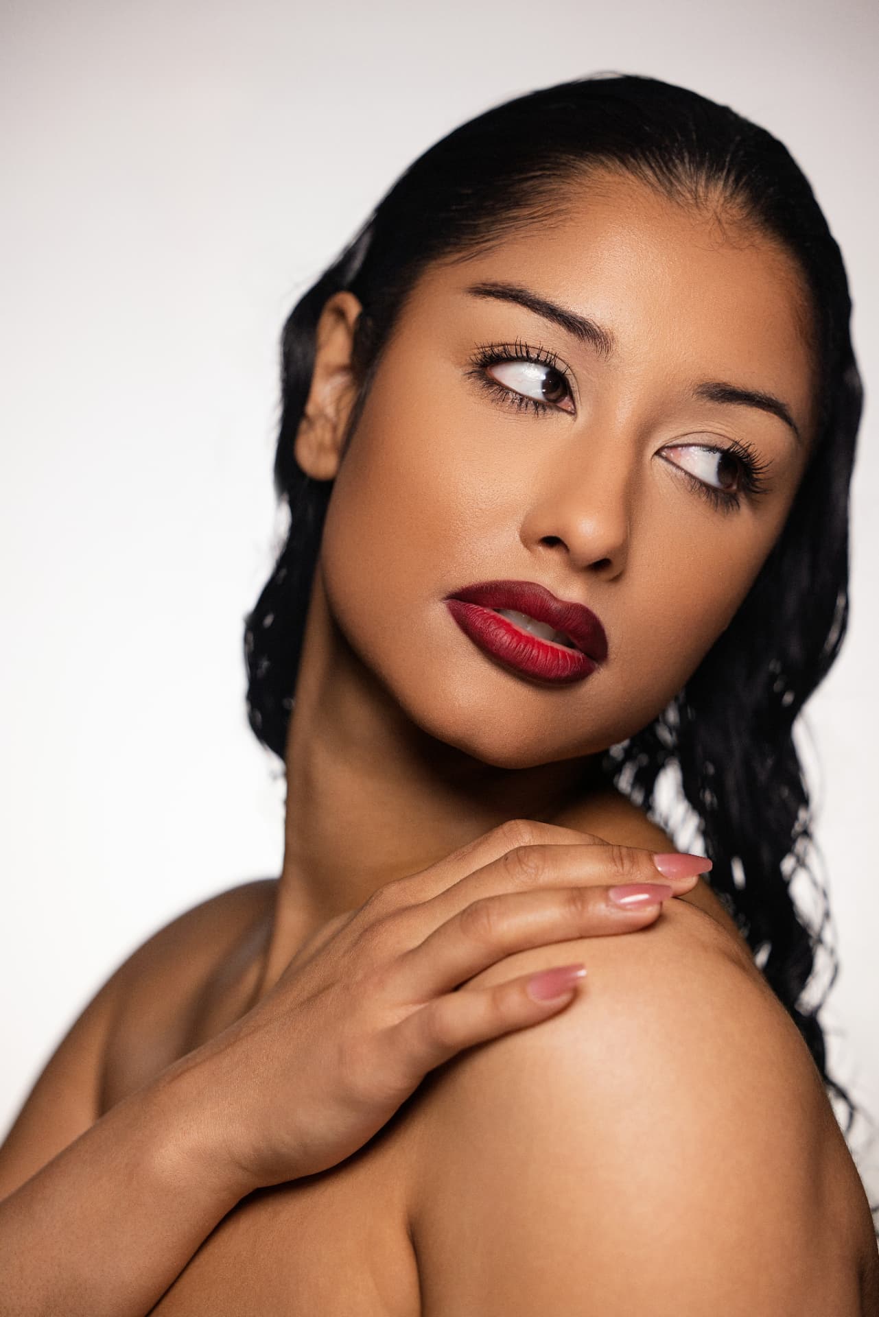 Model wearing a deep red Thee Rich Girls lip